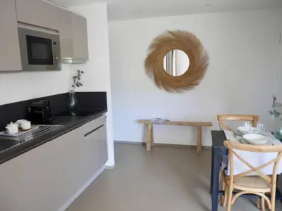a kitchen with a table and a mirror on the wall at 2 pièces vue mer à 3 min des plages in Propriano