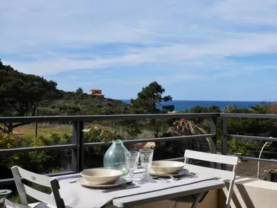 a table with bowls and glasses on a balcony at 2 pièces vue mer à 3 min des plages in Propriano