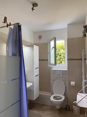 a bathroom with a toilet and a sink and a window at Residence Amanda in Santa-Lucia-di-Moriani