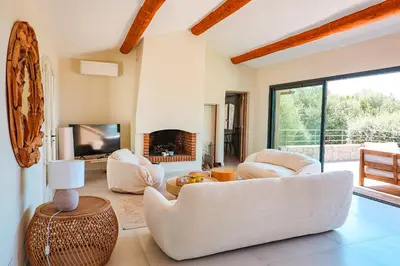 a living room with white furniture and a fireplace at Villa Casta Joia Di Cirendinu in Sainte-Lucie de Porto-Vecchio