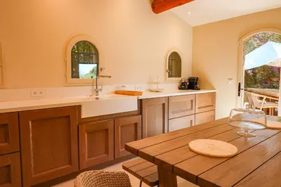 a large kitchen with a wooden table and a wooden table sidx sidx sidx at Villa Casta Joia Di Cirendinu in Sainte-Lucie de Porto-Vecchio