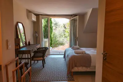 a bedroom with a bed and a desk and a window at Villa Casta Joia Di Cirendinu in Sainte-Lucie de Porto-Vecchio