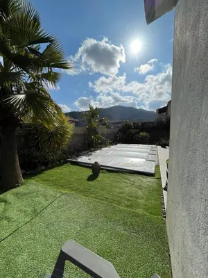 a view of a yard with a lawn with a table at Maison T1 bis Corse in Lucciana