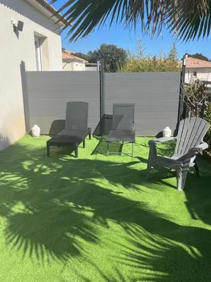 a yard with two lawn chairs and a fence at Maison T1 bis Corse in Lucciana