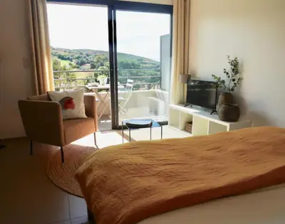 a bedroom with a bed and a large window at Studio 33m² vue mer in Propriano