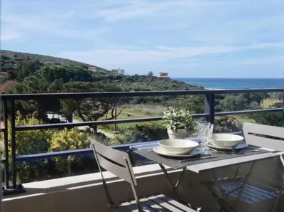 a table on a balcony with a view of the ocean at Studio 33m² vue mer in Propriano