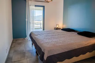 a bedroom with a bed and a large window at BEL'ORIZONTE B , proche centre ville et plage in Propriano