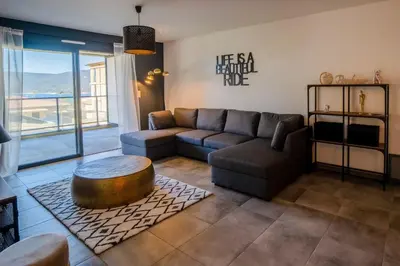a living room with a couch and a table at BEL'ORIZONTE B , proche centre ville et plage in Propriano