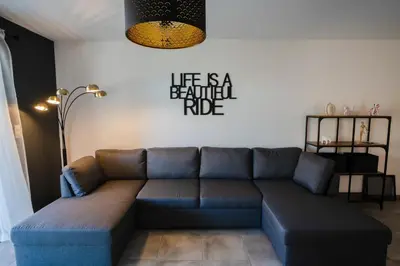 a living room with a couch and a sign that reads life is a settled ride at BEL'ORIZONTE B , proche centre ville et plage in Propriano