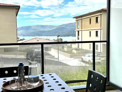 a table with a view of the ocean from a window at BEL'ORIZONTE B , proche centre ville et plage in Propriano