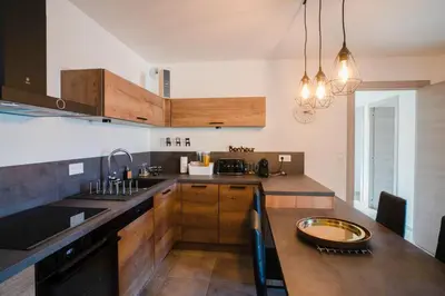 a kitchen with wooden cabinets and a counter top at BEL'ORIZONTE B , proche centre ville et plage in Propriano