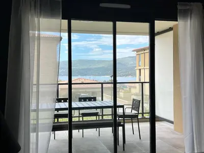 a view of a balcony with a table and chairs at BEL'ORIZONTE B , proche centre ville et plage in Propriano