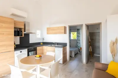 a kitchen and dining room with a table and chairs at Costa Marina in Porto-Vecchio