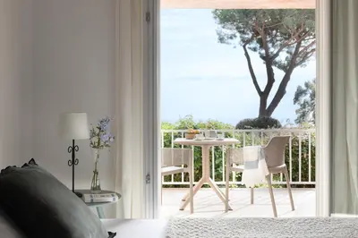a bedroom with a door open to a patio with a table at Costa Marina in Porto-Vecchio