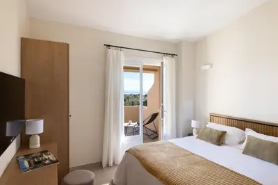 a bedroom with a bed and a sliding glass door at Costa Marina in Porto-Vecchio