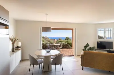 a kitchen and living room with a table and chairs at Costa Marina in Porto-Vecchio