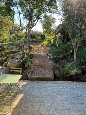a stone walkway with a bench and a table at T2 Rocca in Sotta