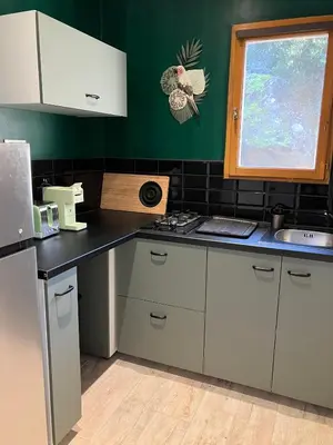 a kitchen with white cabinets and a black counter top at T2 Rocca in Sotta