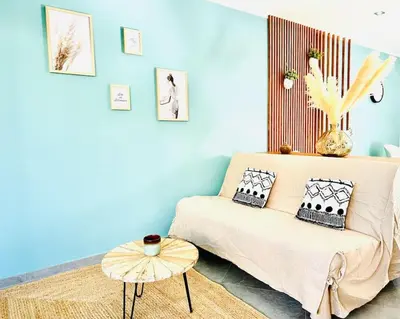 a blue room with a bed and a table at T2 « Bohème » avec Spa… in Calenzana