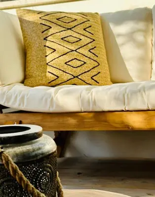 a couch with a pillow and a vase at T2 « Bohème » avec Spa… in Calenzana