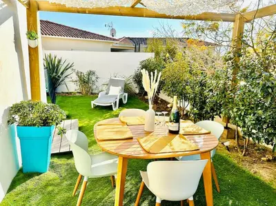 a patio with a wooden table and chairs in a yard at T2 « Bohème » avec Spa… in Calenzana