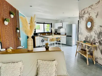 a kitchen and dining room with a table and a refrigerator at T2 « Bohème » avec Spa… in Calenzana