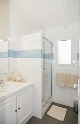 two beds in a room with a window and two lamps at Les Terrasses de Scalegiu in Porto-Vecchio