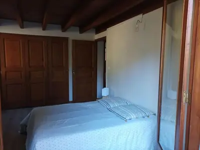 a bedroom with a bed and two wooden doors at Appartement avec vue sur la montagne in Vico