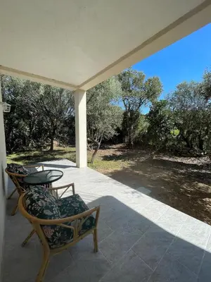 a patio with two chairs and a table on a porch at Villa Casa Sognu di Orizonte in Figari