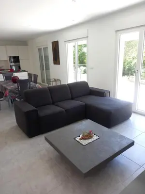 a living room with a black couch and a table at Villa Casa Sognu di Orizonte in Figari