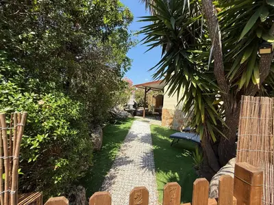 a garden with a gravel path and a bench at Studio de charme à 300 m de la Plage de Santa Giulia in Porto-Vecchio
