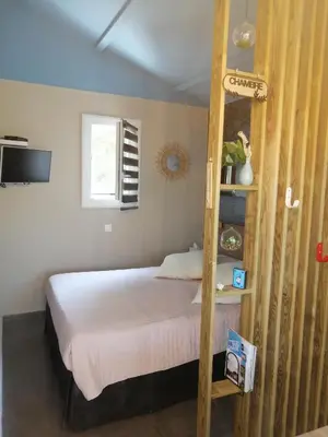 a bedroom with a bed with a wooden ladder at Studio de charme à 300 m de la Plage de Santa Giulia in Porto-Vecchio