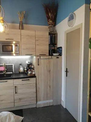 a kitchen with wooden cabinets and a door in a room at Studio de charme à 300 m de la Plage de Santa Giulia in Porto-Vecchio