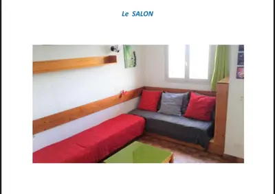 a small living room with a red and grey couch at Appartement terrasse 1 chambre in Porticcio