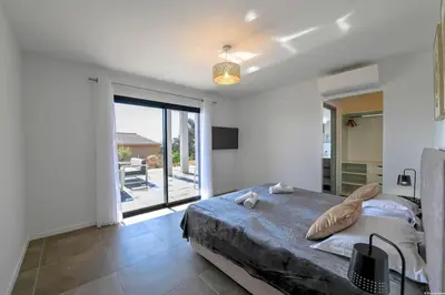 a bedroom with a large bed and a large window at LA MAISON ORIZONTI in Cirendinu