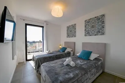 a bedroom with two beds and a large window at LA MAISON ORIZONTI in Cirendinu