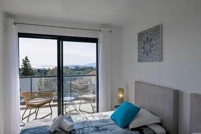 a bedroom with a bed and a view of a balcony at LA MAISON ORIZONTI in Cirendinu