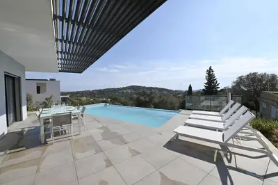 a patio with a table and chairs and a swimming pool at LA MAISON ORIZONTI in Cirendinu