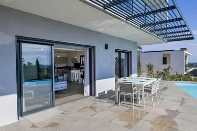 a patio with a table and chairs and a swimming pool at LA MAISON ORIZONTI in Cirendinu