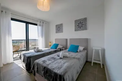 two beds in a room with a large window at LA MAISON ORIZONTI in Cirendinu