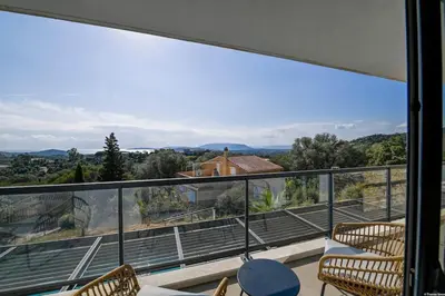 a balcony with chairs and a view of a house at LA MAISON ORIZONTI in Cirendinu