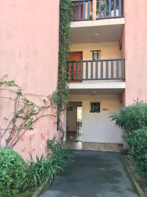 an exterior view of a pink building with a balcony at Grand studio rte des sanguinaires Superbe vue Mer in Ajaccio