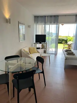 a living room with a glass table and a couch at Grand studio rte des sanguinaires Superbe vue Mer in Ajaccio
