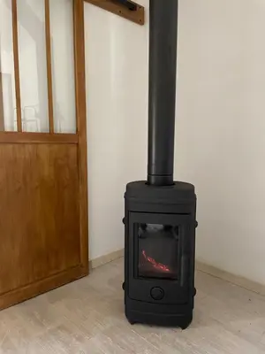 a black stove sitting in a room next to a door at BERGERIE LA NEPITA in Saint-Florent
