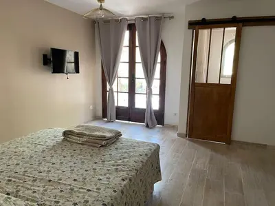 a bedroom with a bed and a large window at BERGERIE LA NEPITA in Saint-Florent