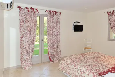 a bedroom with a bed and a window with curtains at Domaine Finili in Cauro