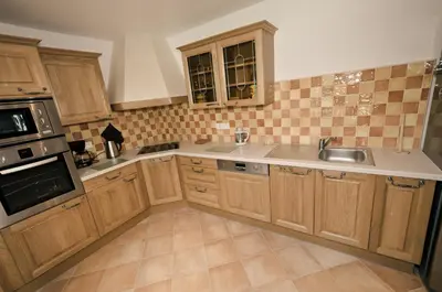 a kitchen with wooden cabinets and a sink at Domaine Finili in Cauro