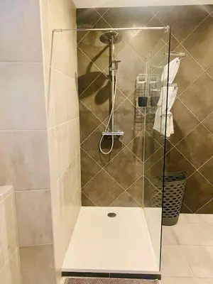 a shower with a glass door in a bathroom at LE RELAIS DES COLS in Cozzano