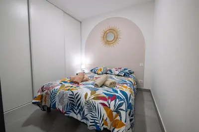 a bedroom with a bed with a colorful blanket at N10 Maison T2 climatisé avec jacuzzi privé in Ajaccio