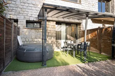 an outdoor patio with a table and an ottoman at N10 Maison T2 climatisé avec jacuzzi privé in Ajaccio